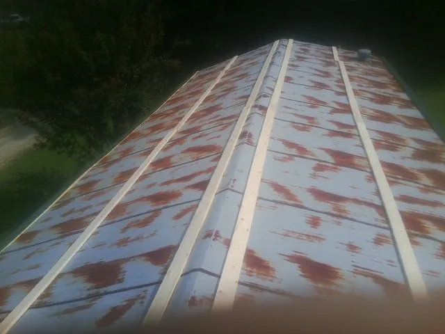 Rusted metal roof panels with new wood purlins before replacement — Storm Damage Roof Repair in Stoystown by Roofing Brothers