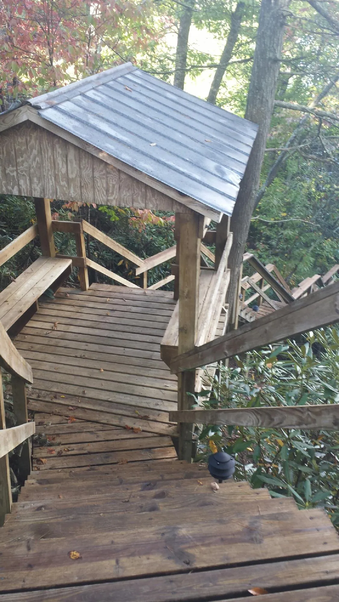 Metal roofed shelter over wooden steps on a wooded walkway — Skylight Repair & Installation work by our crew in Stoystown