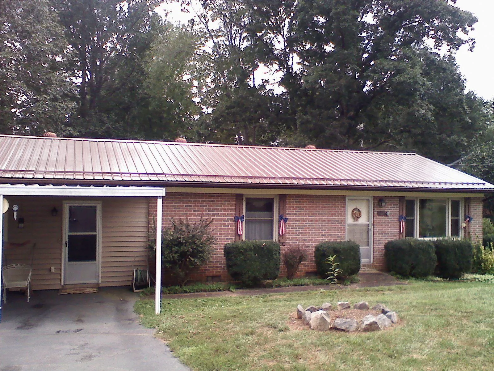 Bronze metal roof and carport on a brick ranch home — Roof Repair work by our crew in Stoystown